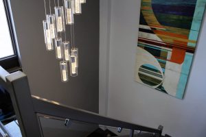 stairway with art on wall and ceiling lamp